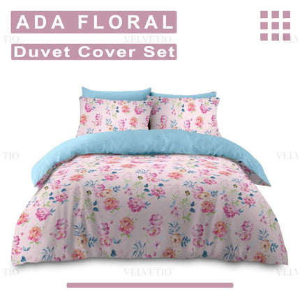 This image showcases the branded identity of the ADA FLORAL Duvet Cover Set by Velvetio, beautifully tying together style and presentation. Set against a warm pink backdrop, the floral-patterned duvet cover and matching pillowcases radiate charm with their colorful blooms and soft texture. A peek of the light blue sheet adds contrast, reinforcing the product’s fresh, inviting appeal. The prominent display of the name “ADA FLORAL Duvet Cover Set” 